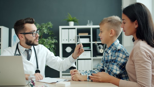 Pediatra atendiendo a una madre con su hijo